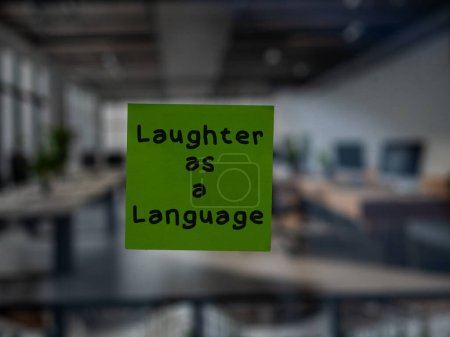 Post note on glass with 'Laughter as a Language'.