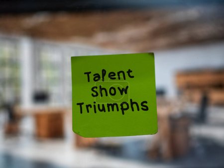 Post note on glass with 'Talent Show Triumphs'.