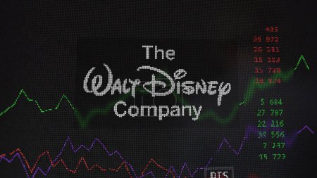 Téléchargez les photos : 19 mars 2024. Le logo de Disney sur l'écran d'un échange. Stocks Disney, DIS $sur un appareil. - en image libre de droit