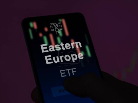 Ein Investor analysiert den Osteuropa-ETF-Fonds auf einem Bildschirm. Ein Telefon zeigt die Preise Osteuropas