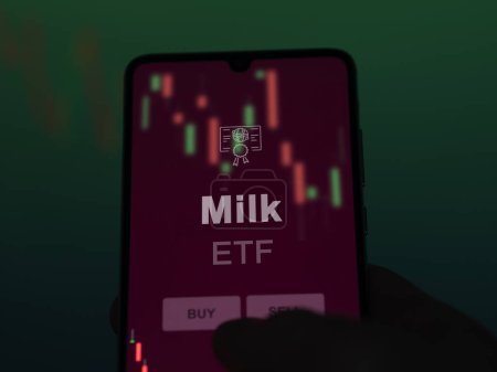 Ein Investor analysiert den Milchfonds auf einem Bildschirm. Ein Telefon zeigt die Milchpreise an