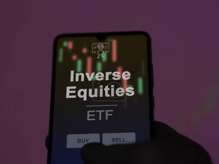 An investor analyzing the inverse equities etf fund on a screen. A phone shows the prices of Inverse Equities