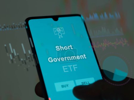 Ein Investor analysiert den Short Government etf Fonds auf einem Bildschirm. Ein Telefon zeigt die Preise von Short Government