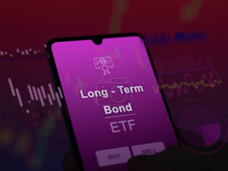 Un inversor que analiza el fondo etf de bonos a largo plazo en una pantalla. Un teléfono muestra los precios de Long - Term Bond