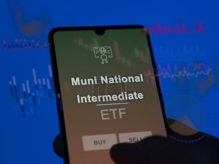 An investor analyzing the muni national intermediate etf fund on a screen. A phone shows the prices of Muni National Intermediate
