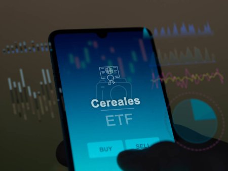 An investor analyzing the cereales etf fund on a screen. A phone shows the prices of Cereales