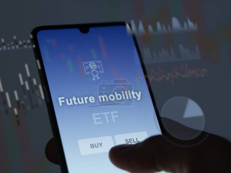 Ein Investor analysiert den zukünftigen Mobilitätsfonds auf einem Bildschirm. Ein Telefon zeigt die Preise der Mobilität der Zukunft