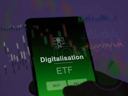 An investor analyzing the digitalisation etf fund on a screen. A phone shows the prices of Digitalisation