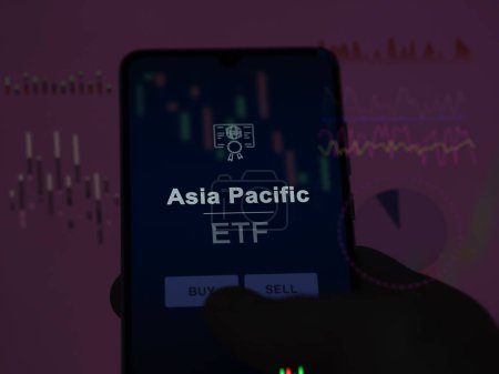 Un investisseur analyse le fonds Asie Pacifique etf sur un écran. Un téléphone montre les prix de l'Asie Pacifique