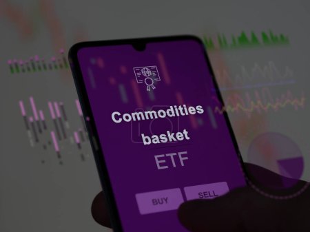 An investor analyzing the commodities basket etf fund on a screen. A phone shows the prices of Commodities basket