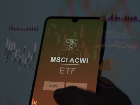 Téléchargez les photos : Un investisseur analysant le fonds msci acwi etf sur un écran. Un téléphone affiche les prix de MSCI ACWI - en image libre de droit