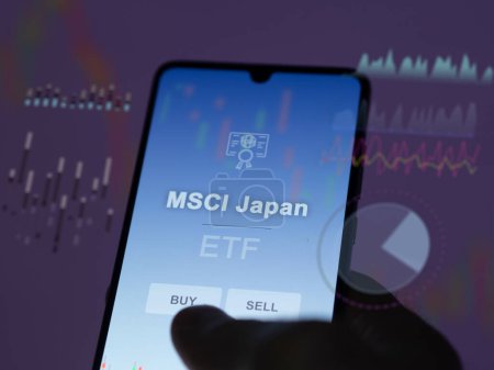 Téléchargez les photos : Un investisseur analysant le fonds japonais msci etf sur un écran. Un téléphone affiche les prix de MSCI Japon - en image libre de droit