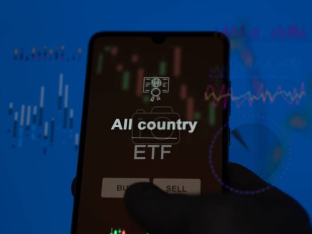 An investor analyzing the all country etf fund on a screen. A phone shows the prices of All country