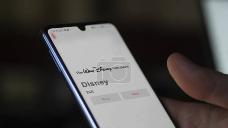 Téléchargez les photos : 04 avril 2024. Le logo de Disney sur l'écran d'un échange. Stocks Disney, DIS $sur un appareil. - en image libre de droit