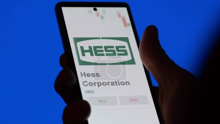 Téléchargez les photos : 04 avril 2024. Le logo de Hess Corporation sur l'écran d'un échange. Stocks de Hess Corporation, $HES sur un appareil. - en image libre de droit