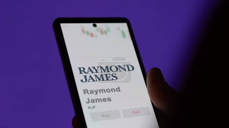 Téléchargez les photos : 04 avril 2024. Le logo de Raymond James sur l'écran d'un échange. Raymond James actions, $RJF sur un appareil. - en image libre de droit
