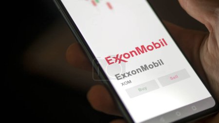 Téléchargez les photos : 04 avril 2024. Le logo d'ExxonMobil sur l'écran d'un échange. Prix des actions ExxonMobil, $XOM sur un appareil. - en image libre de droit
