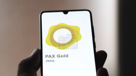 Téléchargez les photos : 20 avril 2024, Shanghai, Chine. Gros plan sur le logo de (PAXG) PAX Gold à l'écran d'un échange. (PAXG) cours de l'or PAX actions, $PAXG sur un appareil. - en image libre de droit