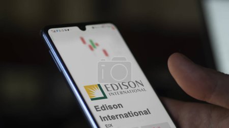 Téléchargez les photos : 09 avril 2024, Rosemead, Californie. Gros plan sur le logo d'Edison International à l'écran d'un échange. Edison International actions de prix, $EIX sur un appareil. - en image libre de droit