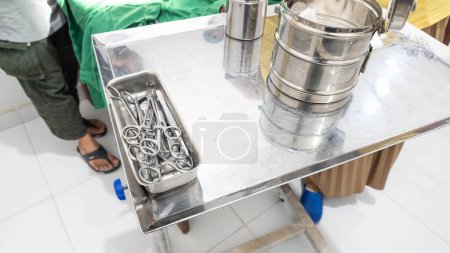Téléchargez les photos : Équipement chirurgical comprenant scalpel, pinces et pince à épiler, sur une table chirurgicale, dans le cabinet d'un chirurgien. shotlisthealth Indonésie - en image libre de droit