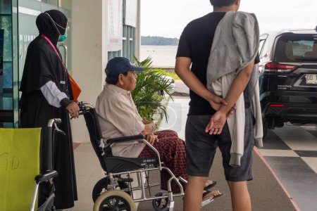 Photo for Pinrang Indonesia, January 10, 2024: photography of a patient who is going home, from Ainun BJ Habibi Hospital, Pare-Pare City, using a pushchair, accompanied by his mother, Asia Indonesia - Royalty Free Image
