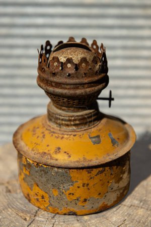 Foto de Una vieja, sucia, oxidada lámpara de queroseno amarillo se encuentra en una tabla de madera - Imagen libre de derechos