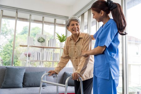 Téléchargez les photos : Les femmes asiatiques sont soignées par des infirmières qui surveillent la santé et la physiothérapie des femmes âgées vivant seules à la maison. en marchant sur une canne ou en utilisant des muscles - en image libre de droit
