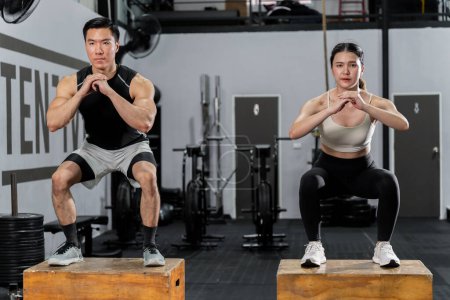 Foto de Los hombres y mujeres asiáticos tienen un cuerpo fuerte, buena salud, les encanta hacer ejercicio. Están haciendo ejercicio juntos en el gimnasio divirtiéndose. - Imagen libre de derechos