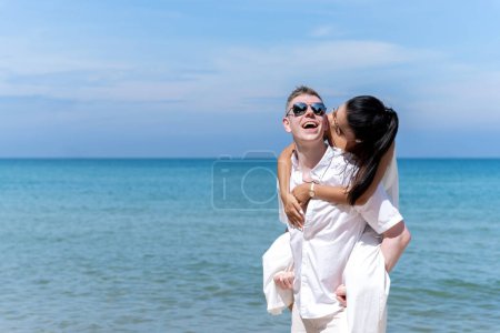 Foto de Un par de hombres y mujeres de diferentes nacionalidades van a la playa y caminan felices juntos por la playa. en vacaciones de verano - Imagen libre de derechos