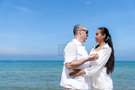 Photo for A couple of men and women of different nationalities go to the beach and walk happily on the beach together. on summer vacation - Royalty Free Image