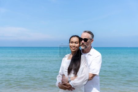 Foto de Un par de hombres y mujeres de diferentes nacionalidades van a la playa y caminan felices juntos por la playa. en vacaciones de verano - Imagen libre de derechos