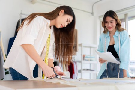 Photo for Two Asian women working together Small business, SME, tailoring designs for customers. Both of them acted as great designers. - Royalty Free Image