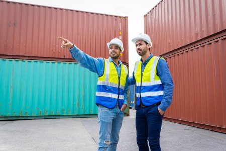 Téléchargez les photos : Deux ingénieurs masculins dans une société de transport de conteneurs Consulting pour vérifier la commande du conteneur qui est responsable - en image libre de droit