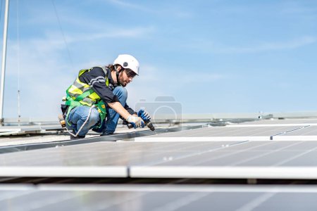 Foto de Male engineer installing or checking the working condition of solar panels on the roof or at the height of the factory for saving electricity was broken to use renewable energy from the sun - Imagen libre de derechos
