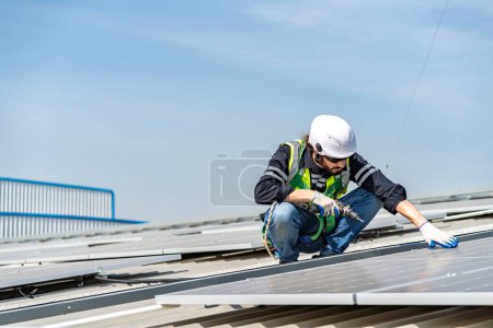 Photo for Male engineer installing or checking the working condition of solar panels on the roof or at the height of the factory for saving electricity was broken to use renewable energy from the sun - Royalty Free Image