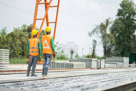 Foto de Male engineers are inspecting and controlling the work of the employees and the quality of the manufactured products to meet the standards In industrial factories producing precast prefabricated walls - Imagen libre de derechos