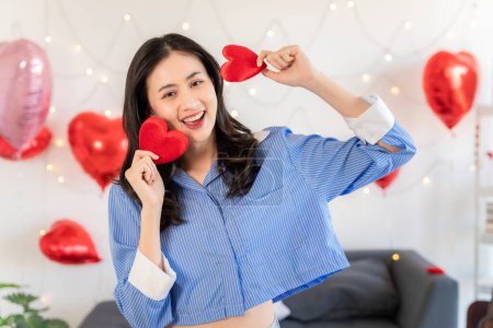 Téléchargez les photos : Asian couple Showing love surprise giving flowers or gifts to each other on important occasions such Valentine's Day birthdays or wedding anniversaries with love and warmth in bedroom of their home - en image libre de droit