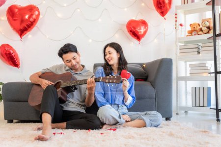 Photo for Asian couple Showing love surprise giving flowers or gifts to each other on important occasions such Valentine's Day birthdays or wedding anniversaries with love and warmth in bedroom of their home - Royalty Free Image