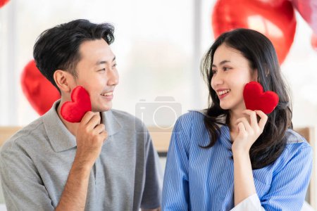 Photo for Asian couple Showing love surprise giving flowers or gifts to each other on important occasions such Valentine's Day birthdays or wedding anniversaries with love and warmth in bedroom of their home - Royalty Free Image