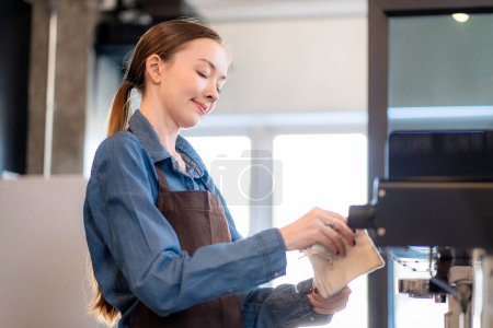 Photo for Coffee shop lady is preparing the equipment for the opening of the shop to serve coffee drinks to customers with standard service, cleanliness and international taste. - Royalty Free Image