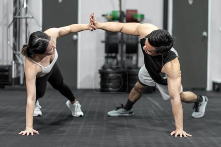 Foto de Asian men and women Have a strong body, good health, love to exercise. They are exercising together at the gym having fun. - Imagen libre de derechos