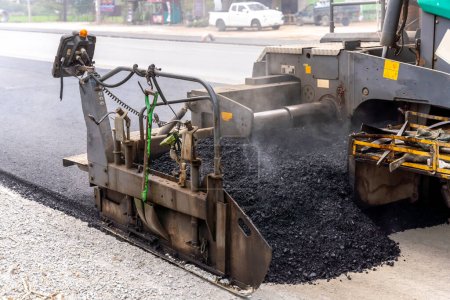 Machines are pouring asphalt to build roads for cars.