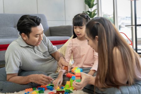 Photo for Asian family portrait There are parents and daughters playing block puzzles at home together having fun and happiness. - Royalty Free Image