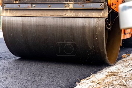 Photo for Machines are crushing the asphalt after pouring to make a road for cars. - Royalty Free Image