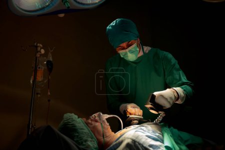 Photo for Team doctors operating room dressed green uniforms saving lives critically patient undergoing heart surgery for heart patients There standardized surgical tools life-saving tool such heart pumps - Royalty Free Image