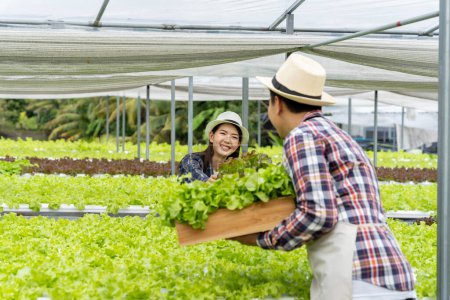 Photo for Male and female couple Asian family picking vegetables Happy inspecting your own hydroponic vegetable garden. - Royalty Free Image