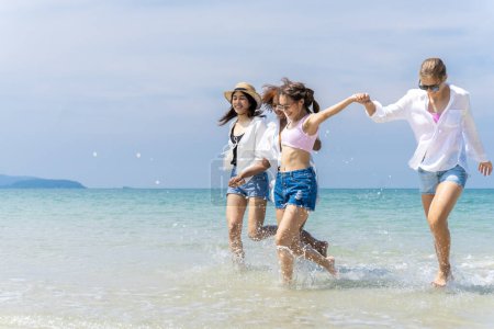 Téléchargez les photos : Photo d'un groupe de filles de différentes ethnies courant et s'amusant ensemble à la plage. un jour frais - en image libre de droit