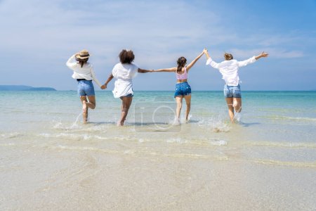 Foto de Foto de un grupo de chicas de diferentes etnias corriendo y divirtiéndose juntas en la playa. en un día fresco - Imagen libre de derechos