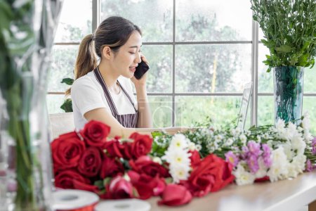 Foto de Grupo de floristas femeninas Asiáticos están organizando flores para los clientes que vienen a pedirlas para diversas ceremonias, como bodas, San Valentín o para dar a sus seres queridos. - Imagen libre de derechos