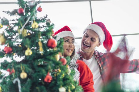 Téléchargez les photos : Un jeune couple fête son Noël ensemble heureux à la maison. - en image libre de droit